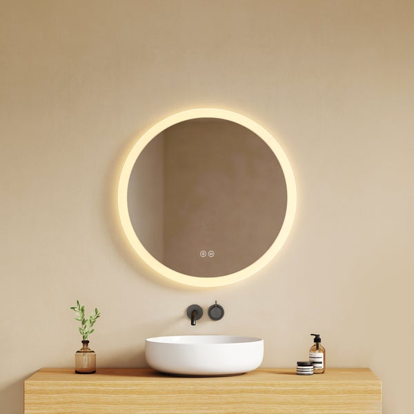 Runder Badspiegel mit umlaufender LED-Beleuchtung über einem weißen Aufsatzwaschbecken auf einer Holzkonsole.