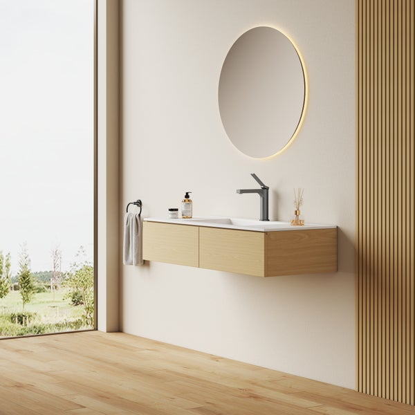 Modernes Badezimmer mit hängendem Waschtisch, rundem LED Spiegel und Armatur in hellem Holzdesign vor einer Wand mit Holzpaneelen.