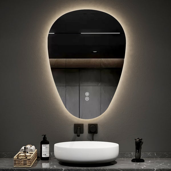 Moderner LED-Badezimmerspiegel in Kieselform mit Hintergrundbeleuchtung über einem weißen Aufsatzwaschbecken und einer schwarzen Wandarmatur.