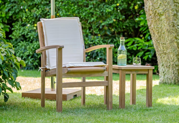 Gartenszene mit Holzstuhl, Sitzkissen und Beistelltisch mit Getränken