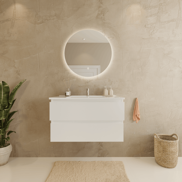 Modernes Badezimmer mit wandhängendem weißem Waschtischunterschrank, zwei Schubladen, rundem beleuchtetem Spiegel und strukturierter Wand.