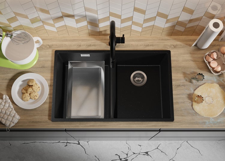 Schwarze Küchenspüle mit Abtropfschale und Armatur auf einer Küchentheke mit Backutensilien