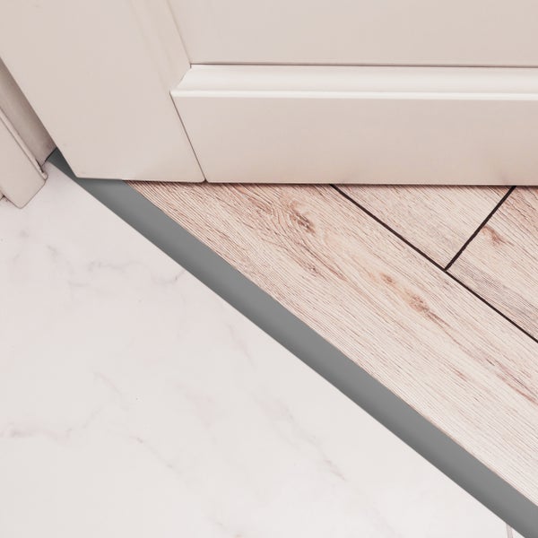 Bodenbeläge aus Laminat und Fliesen getrennt durch ein Übergangsprofil