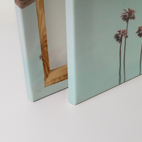 Nahaufnahme von Leinwandbildern mit Palmenmotiven und Holzrahmen