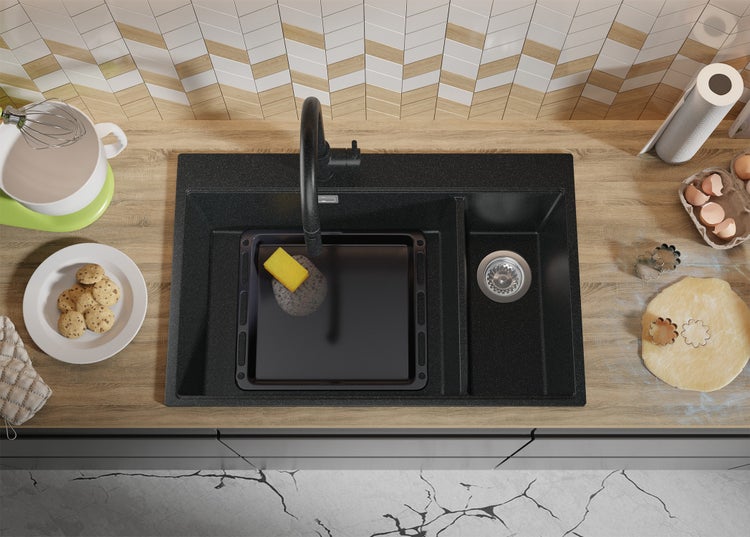 Küchenszene mit schwarzem Spülbecken, Armatur, Backblech und Backutensilien auf einer Arbeitsplatte
