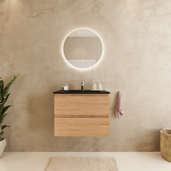 Modernes Badezimmer mit wandhängendem Waschtisch in Holzoptik, schwarzer Platte und rundem, beleuchtetem Spiegel vor strukturierter beige Wand.