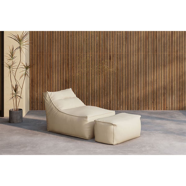 Moderner beigefarbener Sitzsack Sessel und passender Hocker auf einer Terrasse vor einer Holzwand mit einer Pflanze im Topf.