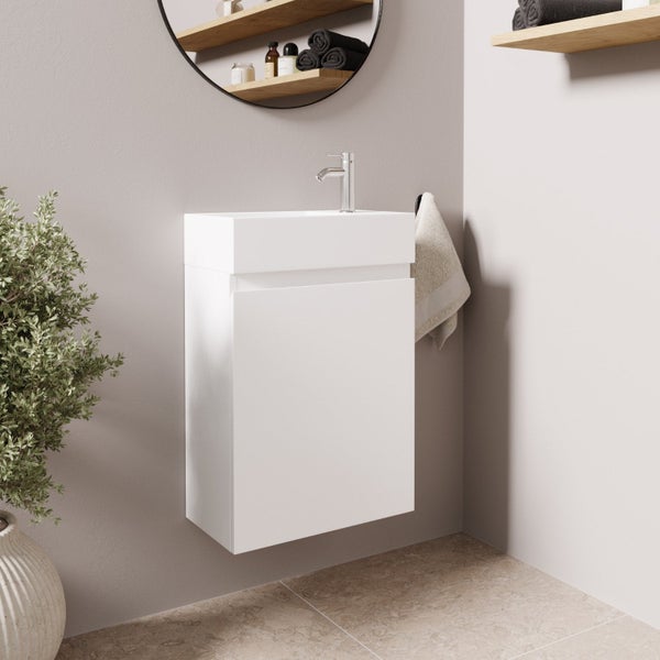Ein moderner, schwebender Waschtischunterschrank mit Waschbecken und Armatur in einem minimalistischen Badezimmer mit Holzablagen und Wandspiegel.