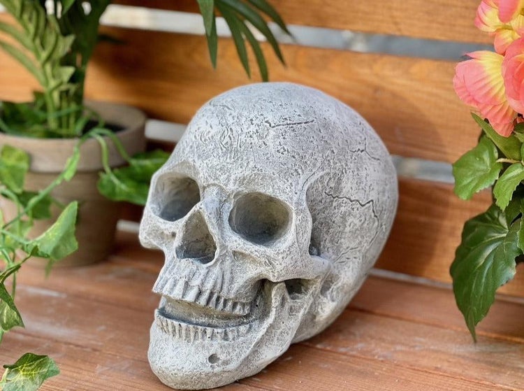 Deko Totenkopf aus Stein für den Garten oder Innenbereich als stilvolle Dekofigur für ein schauriges Ambiente.