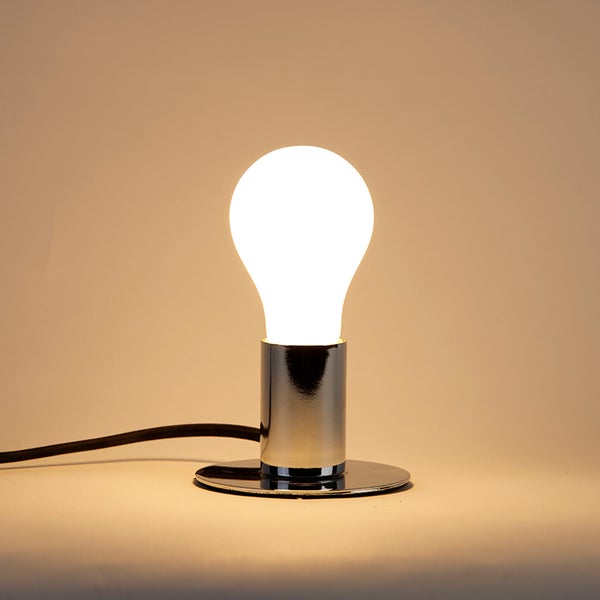 Tischleuchte mit Metallsockel und leuchtender Glühbirne