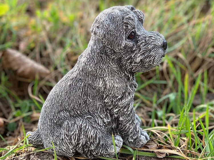 Dekorative Gartenfigur in Form eines sitzenden Hundewelpen aus wetterfestem Kunststein für den Außenbereich.