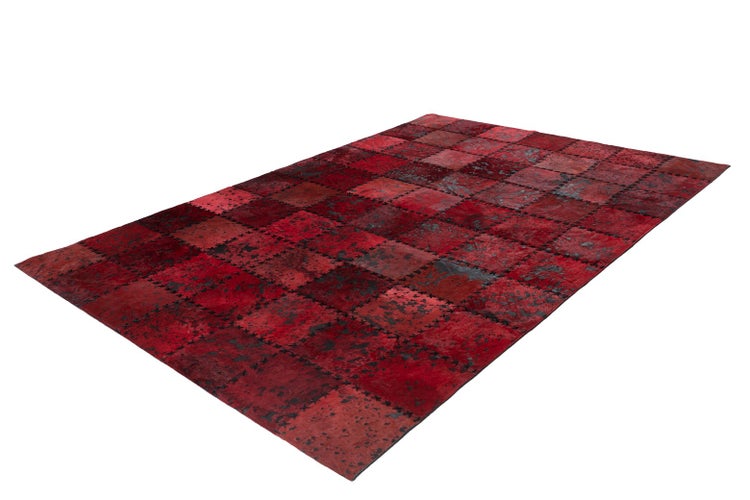Patchwork-Teppich aus Rinderfell in Rot mit quadratischen Mustern und Ziernähten.