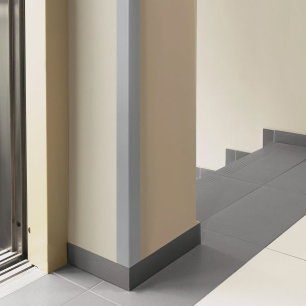 Innenaufnahme einer Wand mit Sockelleiste und Treppe mit Fliesen.