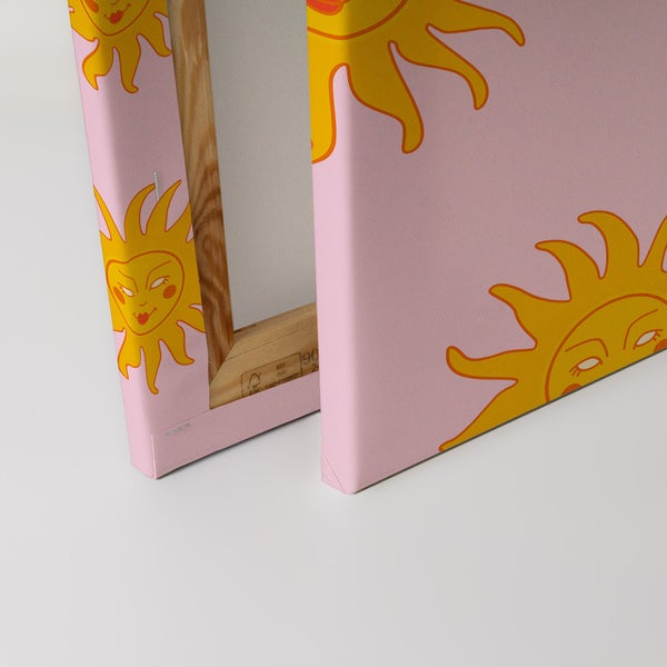 Nahaufnahme einer Leinwand mit einem gelben Sonne-Motiv auf rosafarbenem Hintergrund