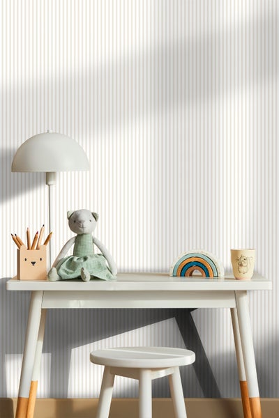 Kindgerechtes Zimmer mit Schreibtisch, Stuhl, Lampe und Dekoration vor gestreifter Tapete