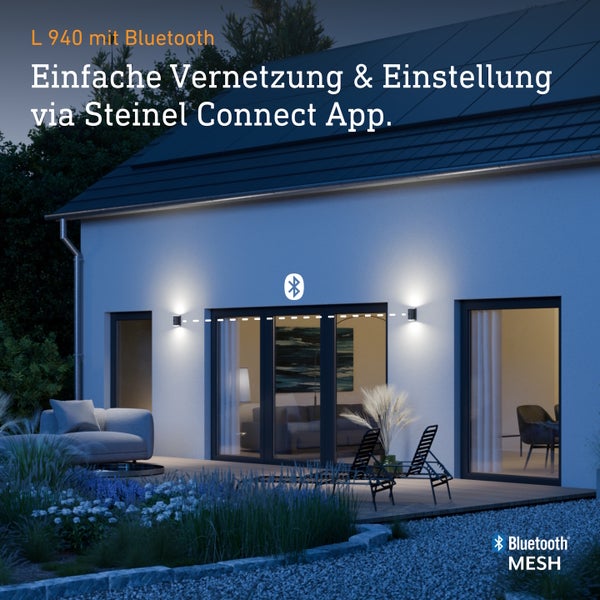 Zwei Außenwandleuchten L 940 an einer Hausfassade bei Nacht, vernetzbar über die Steinel Connect App mit Bluetooth Mesh Technologie.