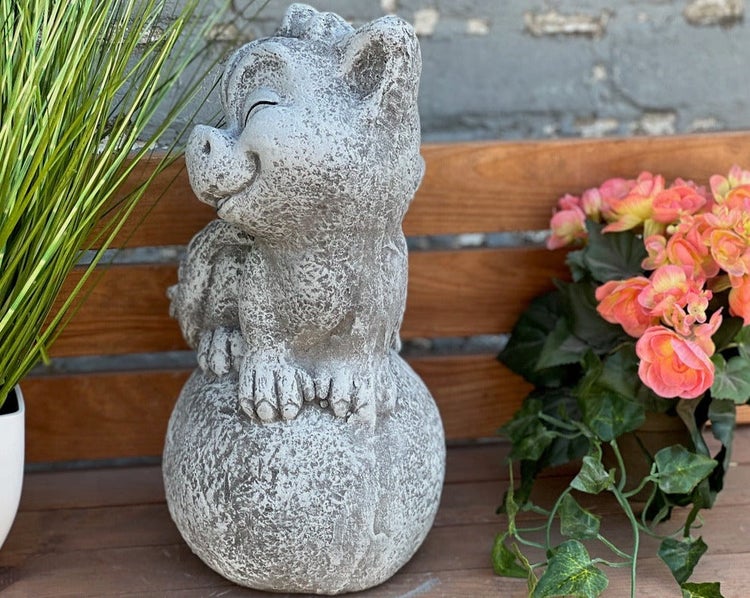 Gartenfigur kleiner Drache auf einer Kugel in Steinoptik.