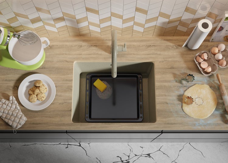 Küchenszene mit Spüle, Küchenmaschine, Keksen und Backzutaten auf einer Arbeitsplatte.