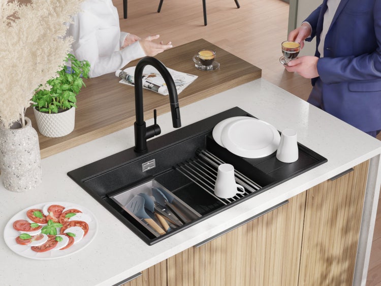 Küchenszene mit schwarzer Spüle, Armatur, Geschirr und Lebensmitteln auf einer Arbeitsplatte.