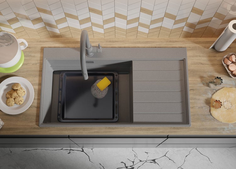 Küchenspüle mit Spülmittel und Backblech auf einer Arbeitsplatte