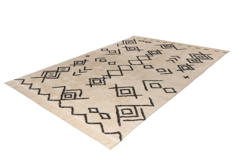 Beiger Teppich mit schwarzen geometrischen Mustern und Fransen, Boho-Stil.