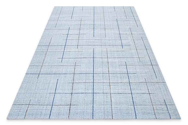 Detailaufnahme der Kante eines blauen Teppichs mit strukturierter Oberfläche.