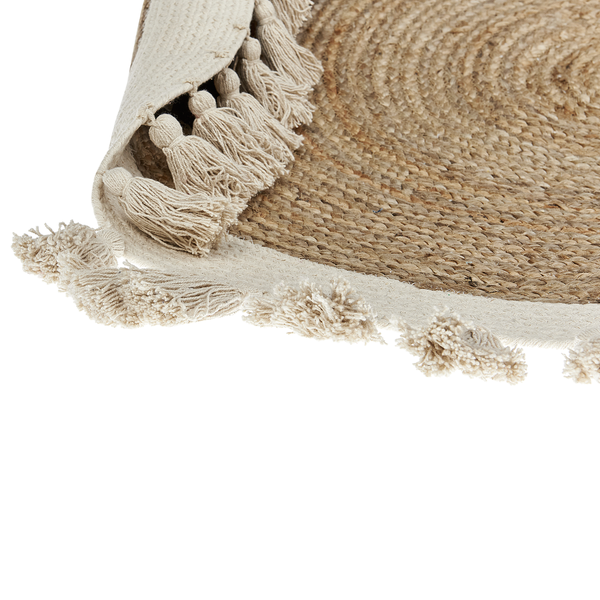 Nahaufnahme eines runden, geflochtenen Juteteppichs mit Quasten am Rand.
