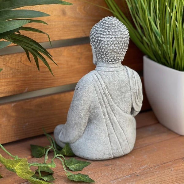 Sitzende Buddha Gartenfigur aus Kunststein, Rückansicht auf einem Holzuntergrund.