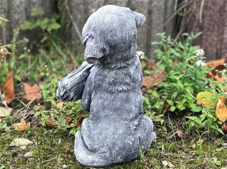 Gartenfigur in Form eines sitzenden Hundewelpen aus wetterfestem Steinguss zur Dekoration im Außenbereich.