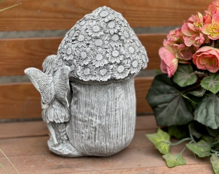 Graue Gartenfigur Elfe an einem Pilzhaus mit Blumendach aus Steinguss für die Gartendekoration.