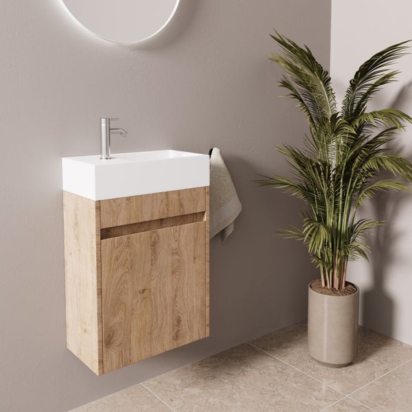 Wandhängender Waschbeckenunterschrank mit Holzoptik Front und integriertem Waschbecken sowie Armatur in einem modern eingerichteten Badezimmer.