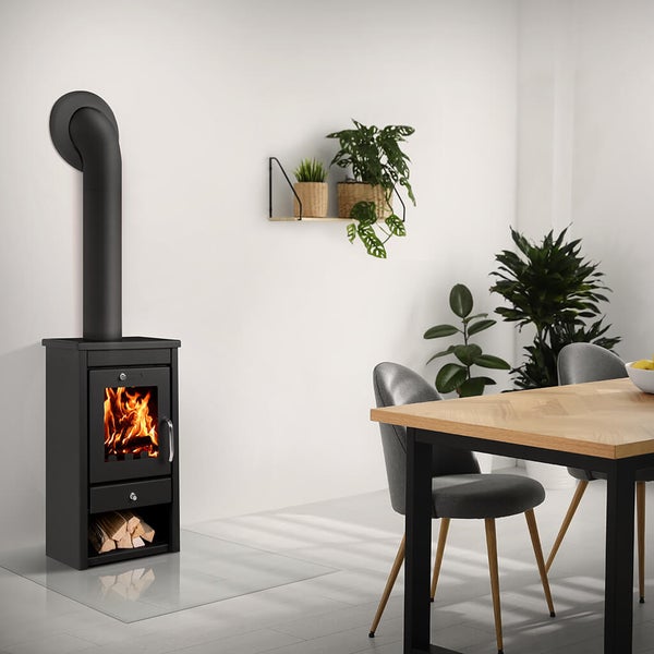 Schwarzer Kaminofen aus Stahl mit brennendem Holz in modernem Esszimmer mit Holztisch und Pflanzen.