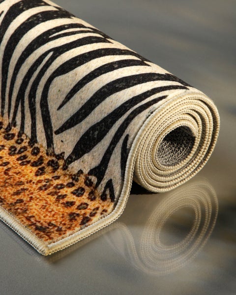 Zusammengerollter Teppich mit Zebra- und Leopardenmuster, eingefasstem Rand und rutschfester Unterseite.