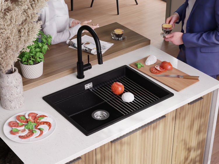 Spüle mit Abtropfgitter und schwarzer Armatur auf einer Küchentheke