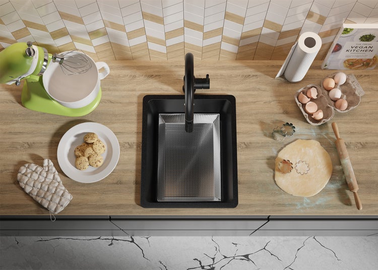 Küchenszene mit Spüle, Armatur, Rührgerät, Backutensilien und Zutaten auf einer Arbeitsplatte.