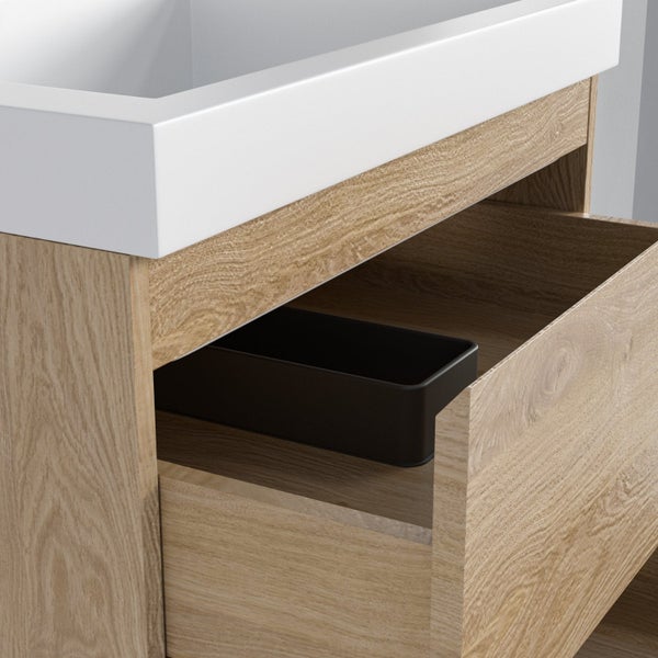 Waschtischunterschrank in Holzoptik mit weißem Waschbecken, offener Schublade und schwarzem Organizer.