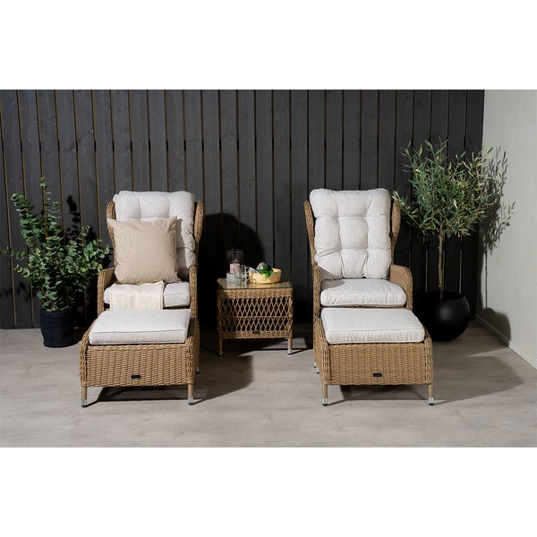Gartenszene mit zwei Rattansesseln, Fußhocker und Beistelltisch