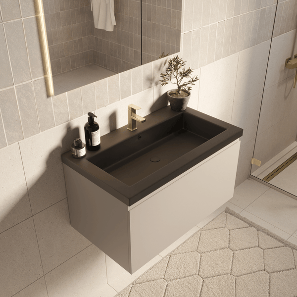 Modernes Badmöbel-Set mit schwarzem Waschbecken, beigem Unterschrank und goldener Armatur in einem hellen, gefliesten Badezimmer.