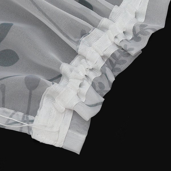 Detailansicht eines Voile-Vorhangs mit Blumenmuster und Rüschenband