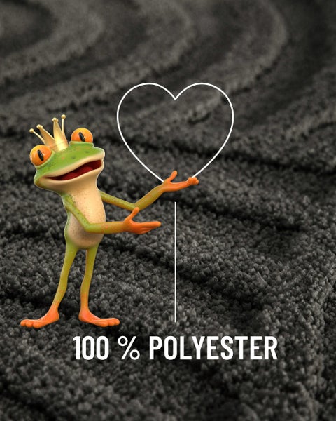Grüner Frosch mit Krone zeigt auf die Materialangabe 100 Prozent Polyester auf einem grauen Teppich.