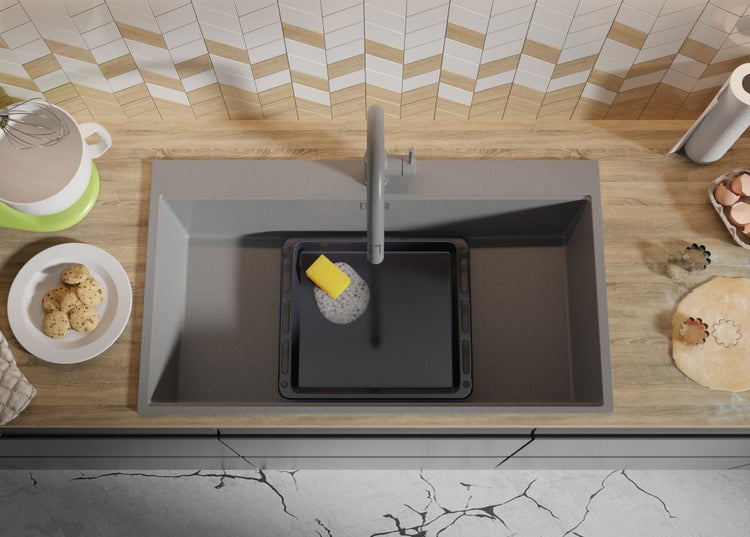 Spüle mit Abtropffläche, Küchenutensilien und Speisen auf einer Küchentheke.