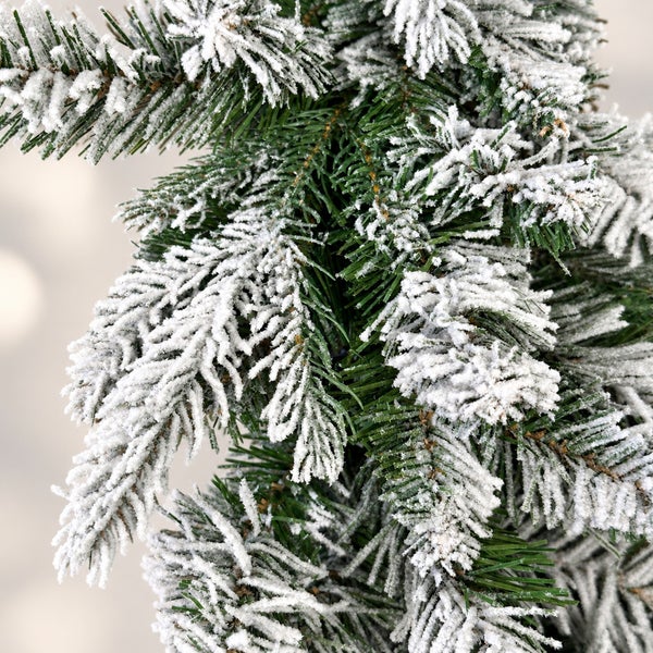Nahaufnahme von künstlichen Tannenbaumzweigen mit weißer Kunstschnee Beschichtung