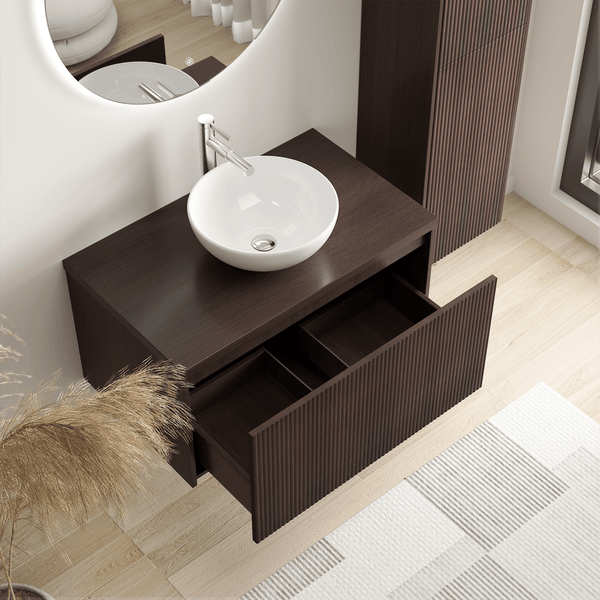 Modernes Badezimmer mit wandhängendem Waschtischunterschrank in dunkler Holzoptik, weißem Aufsatzwaschbecken und offener Schublade mit Rillenstruktur.