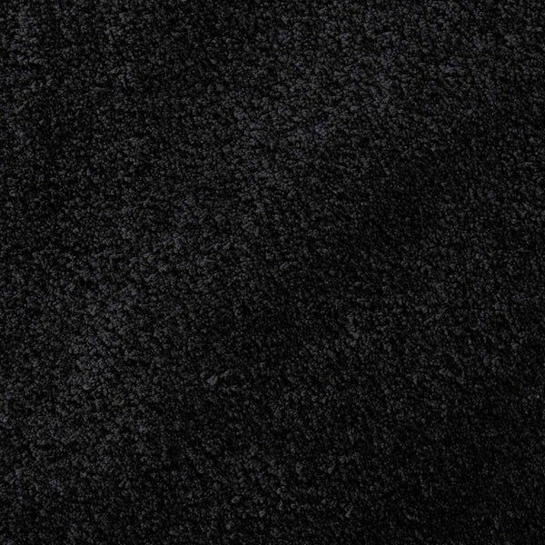 Nahaufnahme eines schwarzen Hochflor-Teppichs mit weicher Struktur.