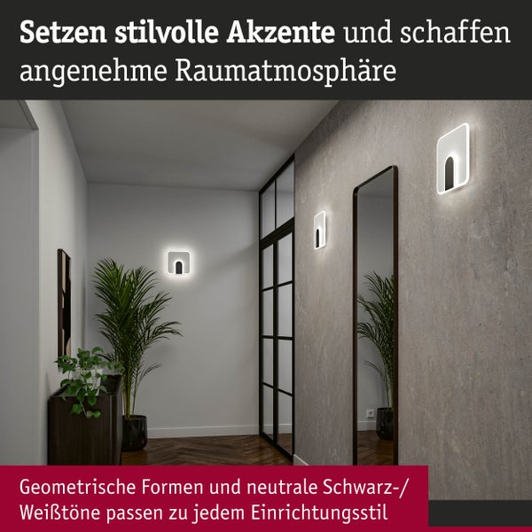 Flur mit zwei Wandleuchten, Spiegel, Tür mit Glaseinsatz und Topfpflanzen