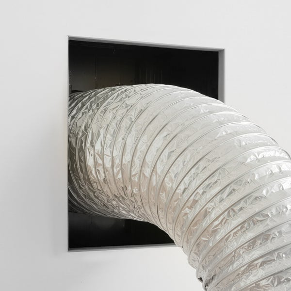 Flexibler Aluminium Abluftschlauch fuer Lueftungssysteme, montiert in einer Wanddurchfuehrung.