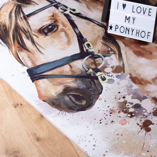 Kinderteppich mit Pferde-Motiv und Zaumzeug in künstlerischer Optik auf Holzfußboden.