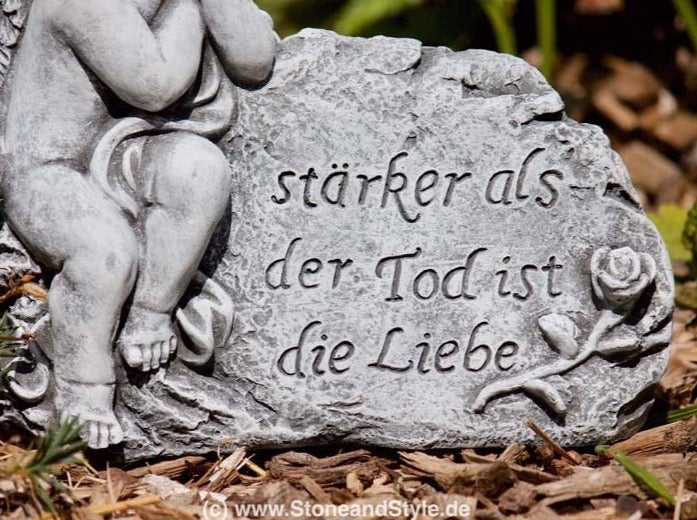 Grabschmuck aus Stein in Form eines Engels mit einer eingravierten Inschrift stärker als der Tod ist die Liebe und einem Rosenmotiv.