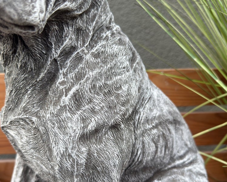 Detailaufnahme einer Hundefigur aus Stein mit strukturierter Felloptik.