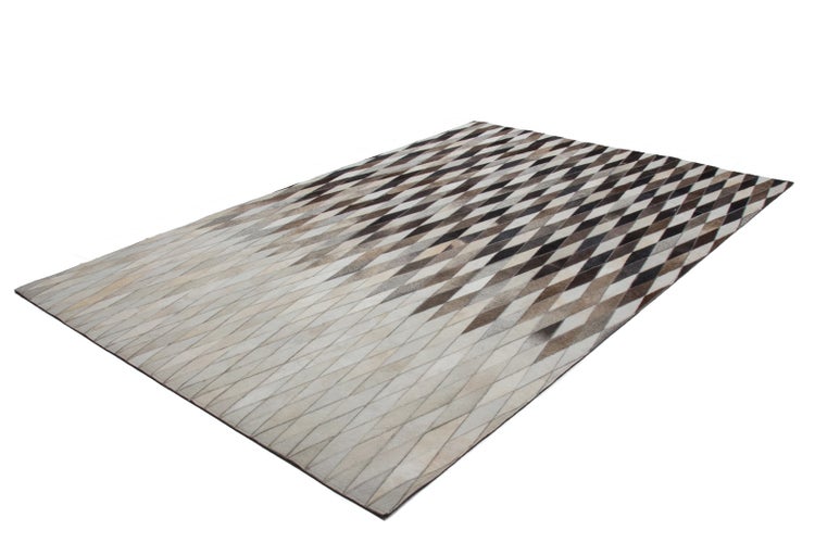 Rechteckiger Teppich aus Kuhfell-Patchwork mit Rautenmuster in Braun- und Grautönen.